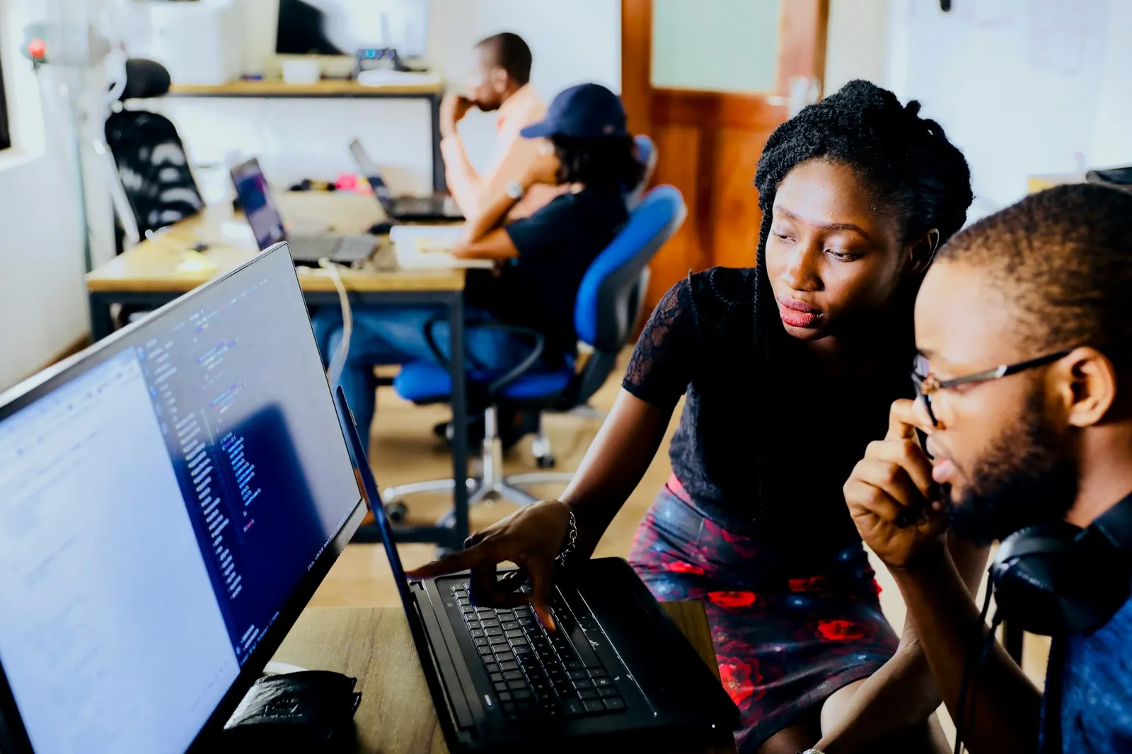 Two developers looking at code on a monitor